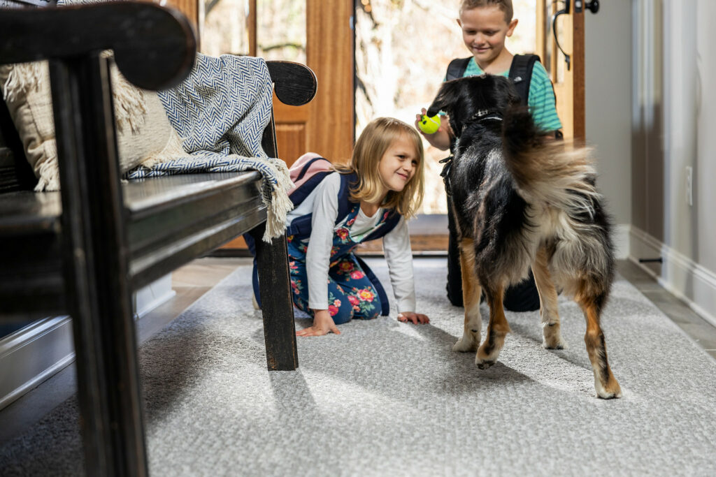 Kids playing with dog on carpet floors | Simple Flooring Solutions